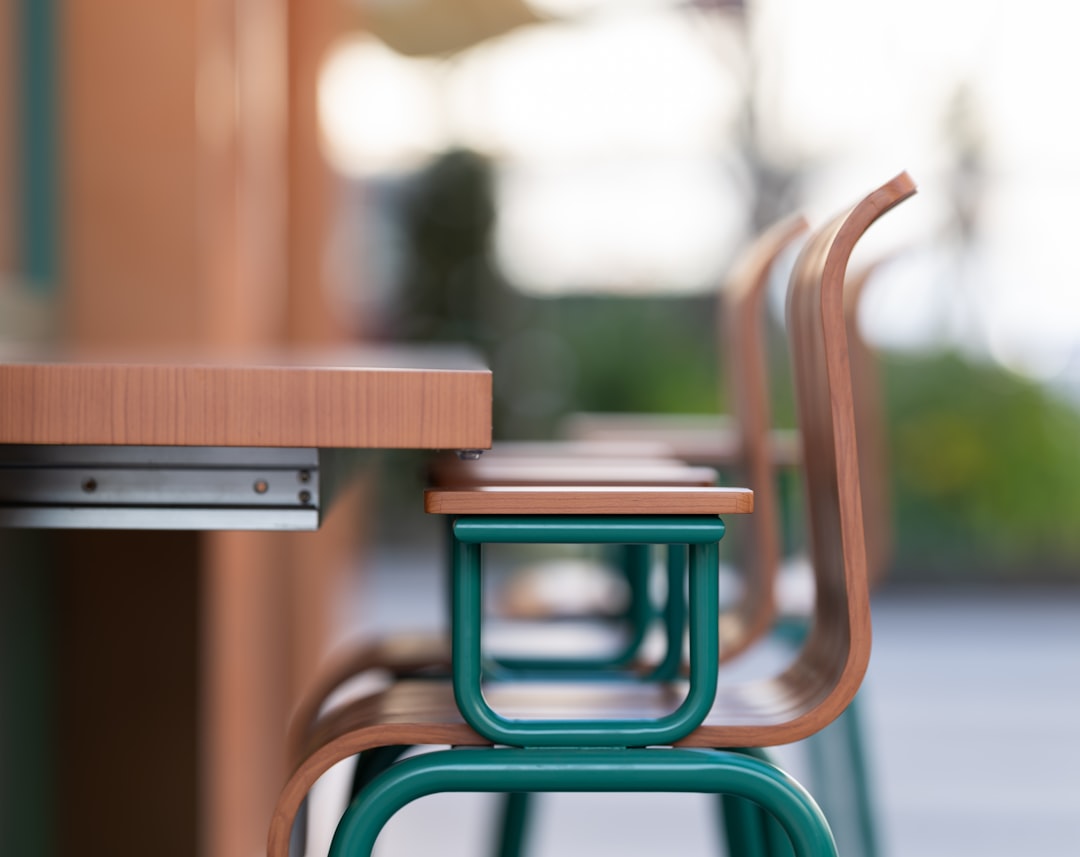 "Rangée de chaises vertes près d'une table en bois, exemple de mobilier urbain sur mesure prix fabrication"