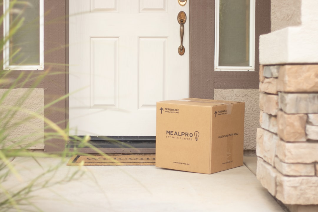 meilleure solution réception colis sécurisée - brown cardboard box beside white wooden door