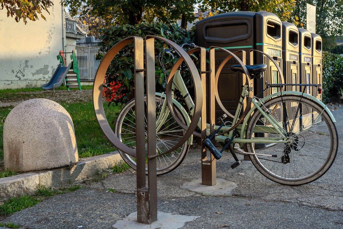 Vélo vintage attaché à un support métallique dans un parc.