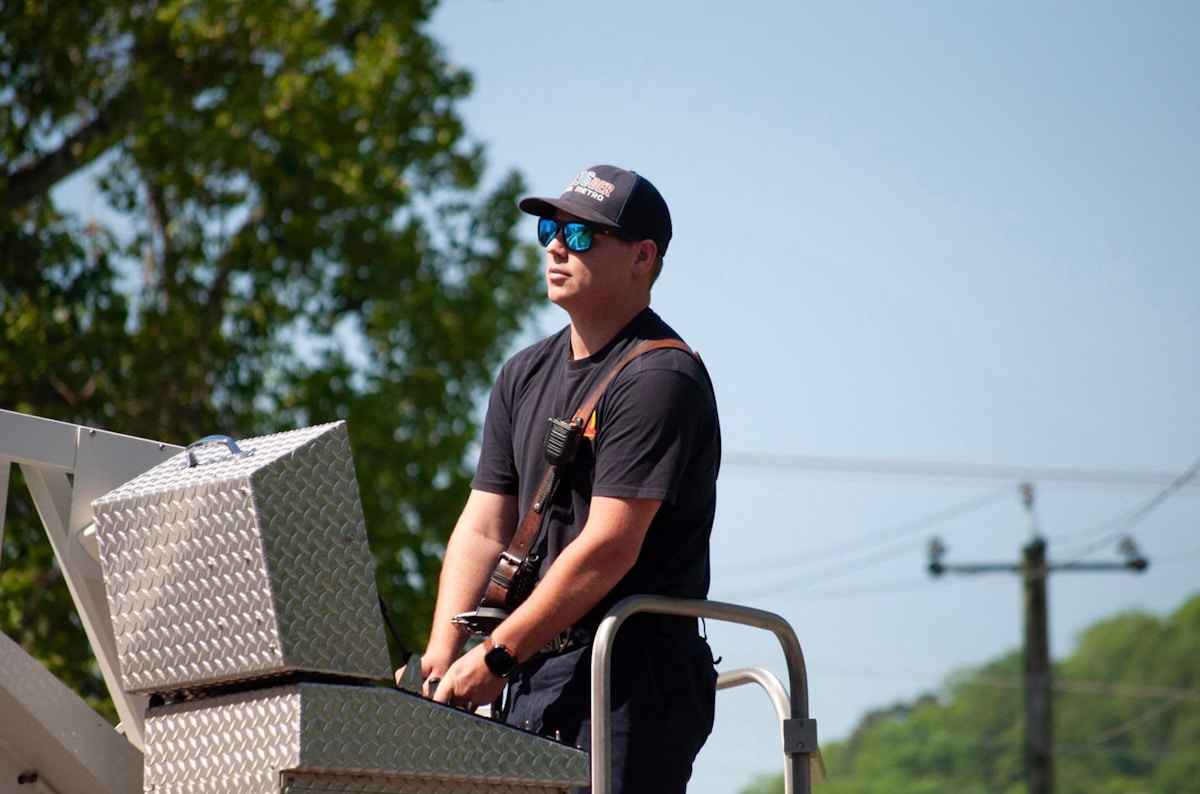 Homme en casquette et lunettes de soleil sur un chariot de travail.