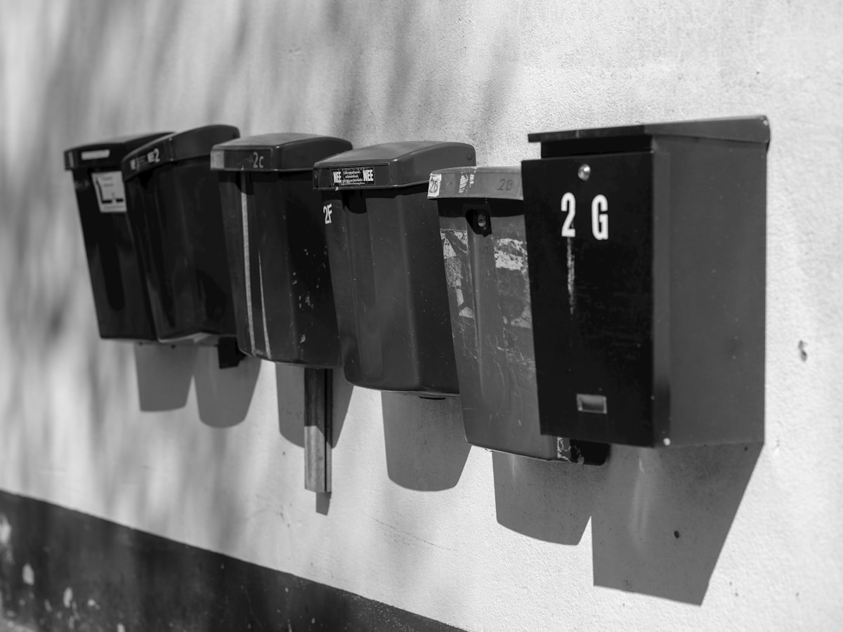 Boîtes aux lettres numérotées alignées sur un mur.