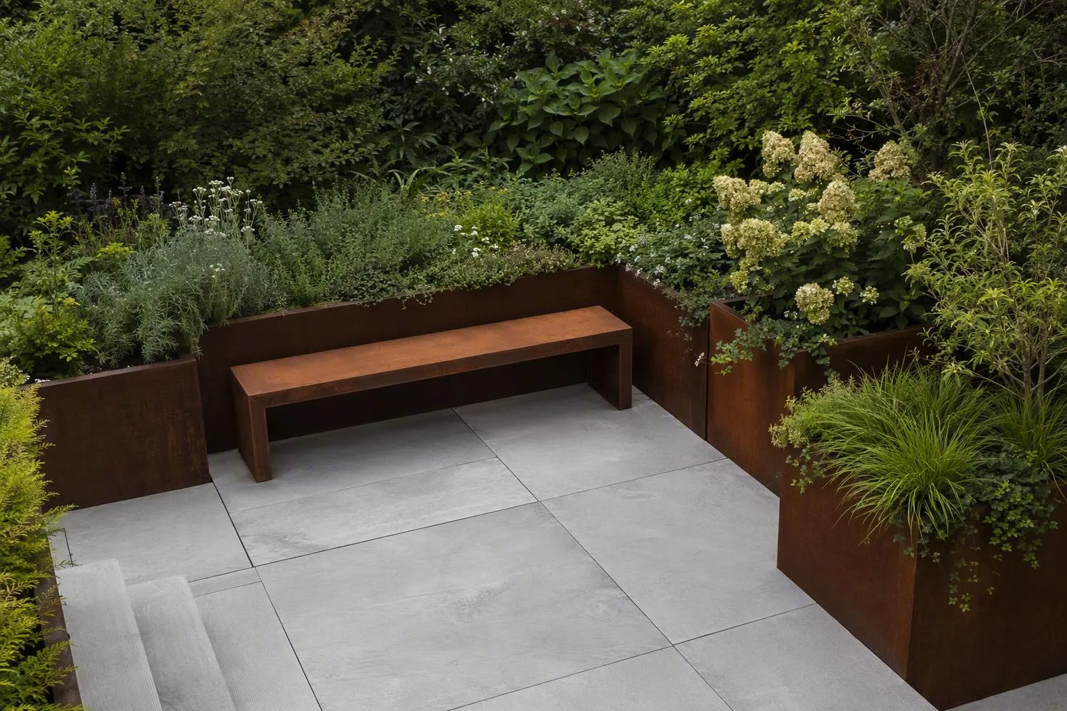 Jardin luxuriant avec banc en métal, carrelage gris et végétation abondante.