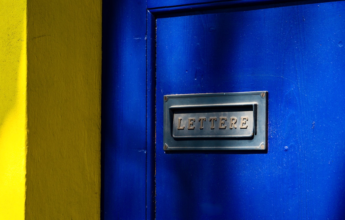 Porte bleue avec boîte aux lettres en métal.