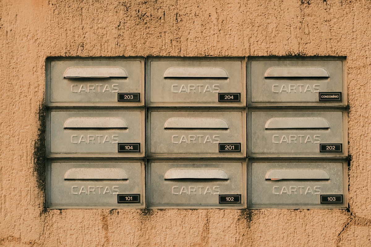 Neuf boîtes aux lettres murales numérotées, alignées en grille