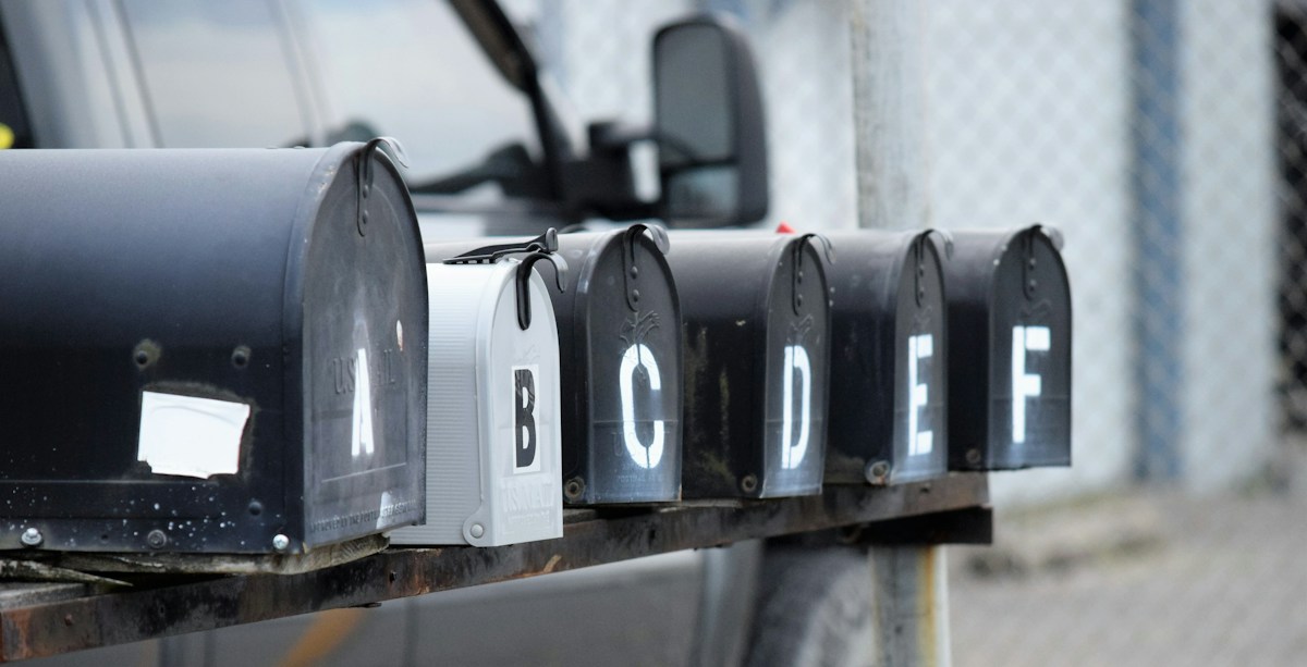 Rangée de boîtes aux lettres noires et blanches.