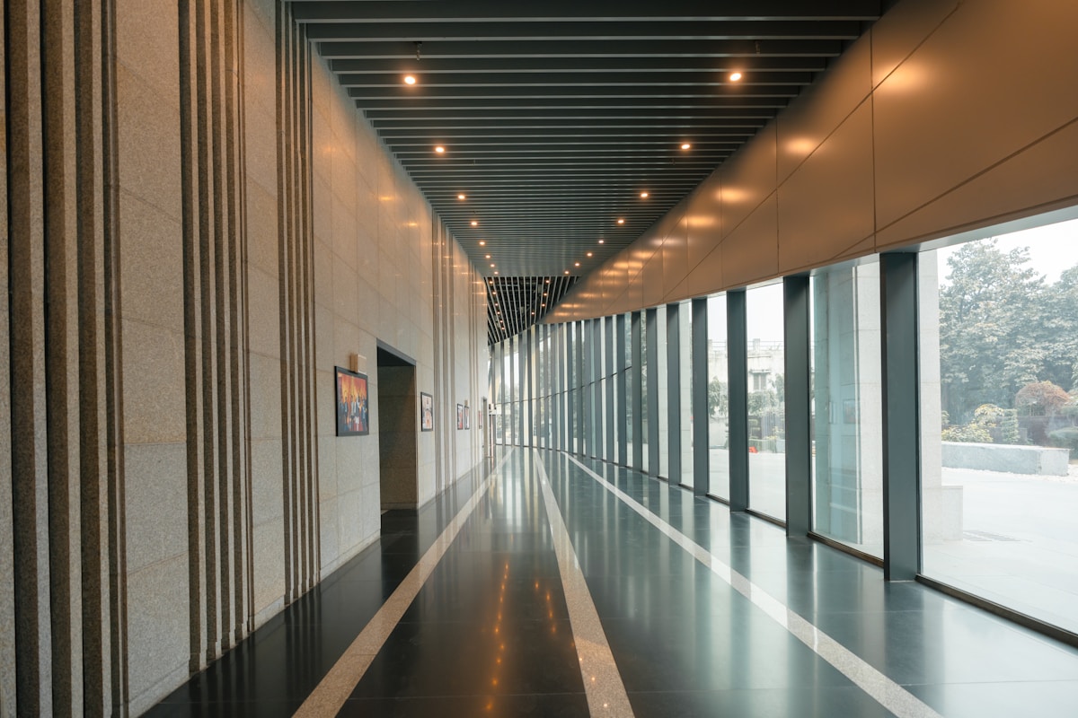 Couloir intérieur moderne avec éclairage indirect et fenêtres panoramiques.