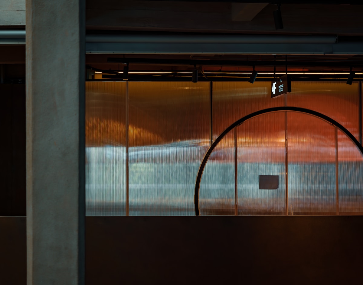Fenêtres en verre teinté, éclairage intérieur, structure métallique.