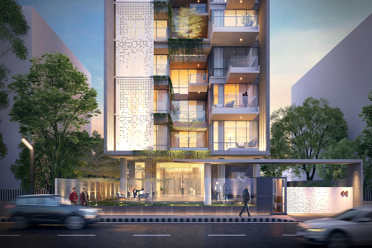 Immeuble moderne avec façade perforée, balcons végétalisés et éclairage chaleureux.