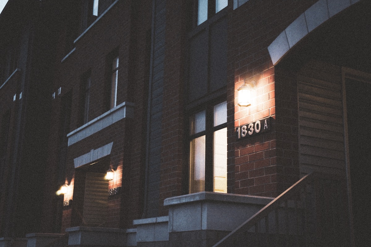 Bâtiment sombre avec numéro d'adresse éclairé la nuit.