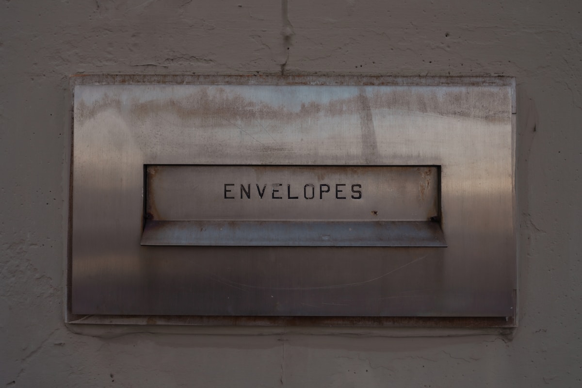 Boîte murale en métal usagée avec l'inscription "Envelopes".