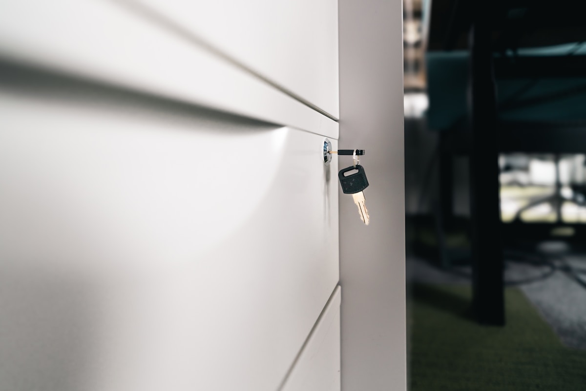 Clé de porte accrochée sur un mur blanc.