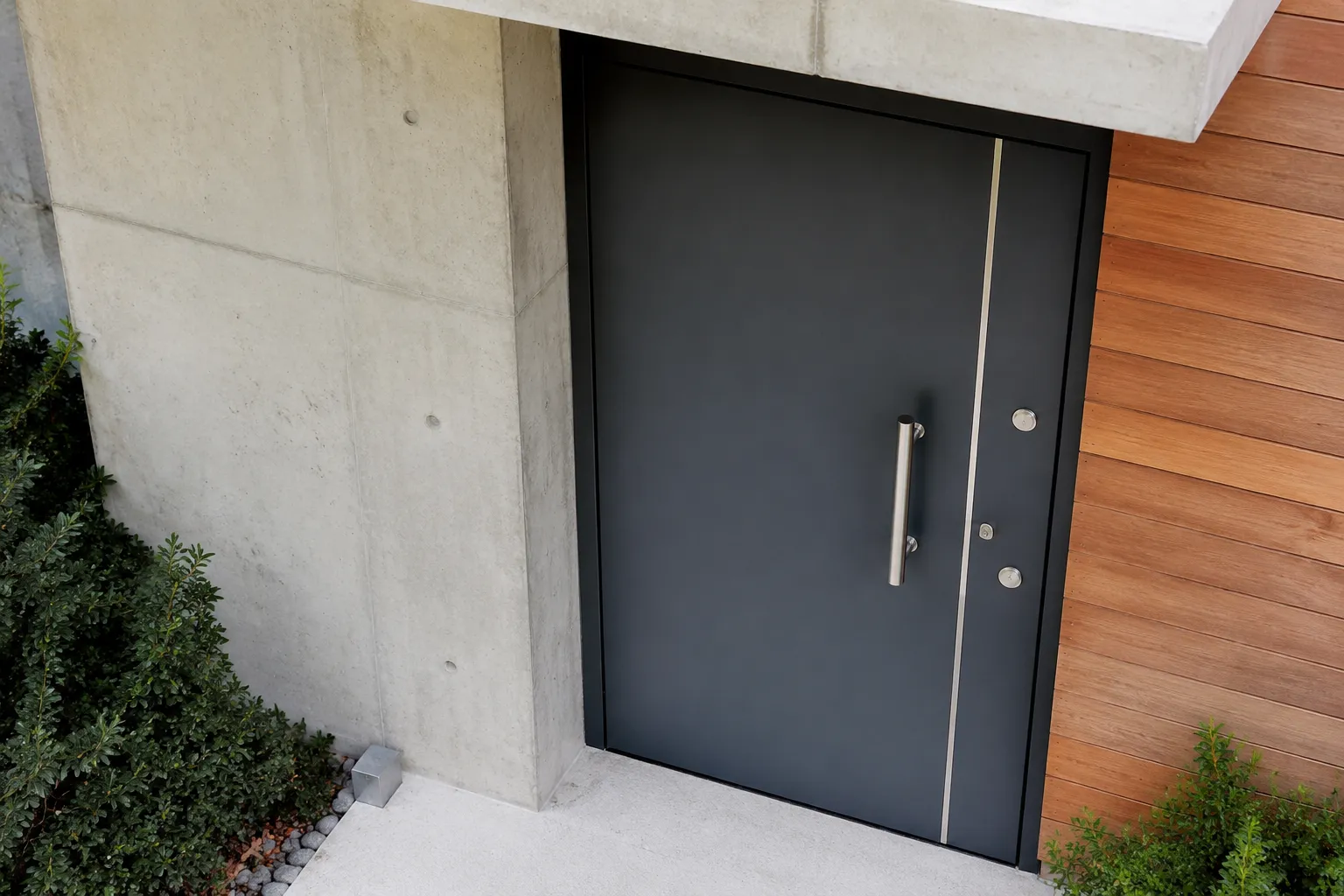Porte d'entrée moderne en métal noir avec poignée en métal.