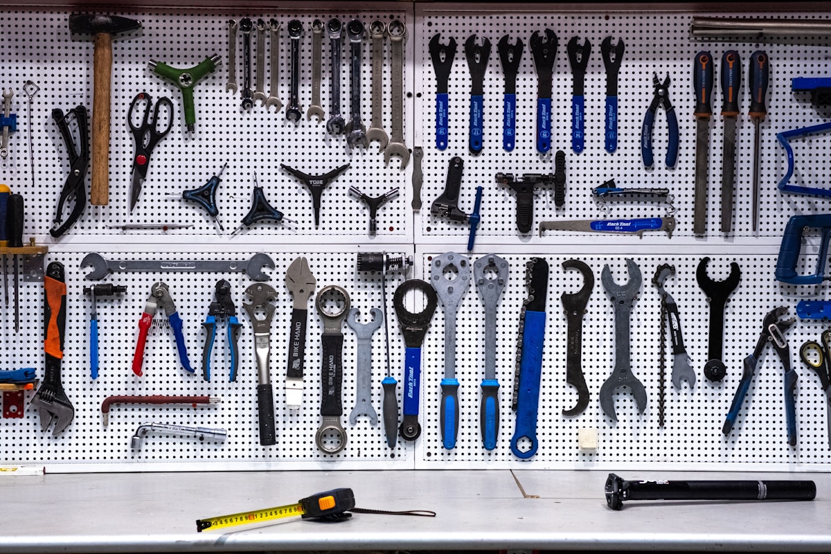 Mur perforé rempli d’outils de mécanique et bicyclettes