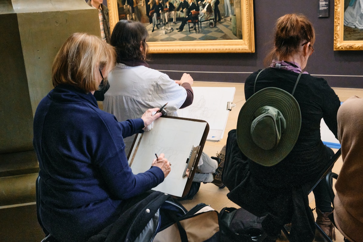 A group of people looking at paintings in a museum