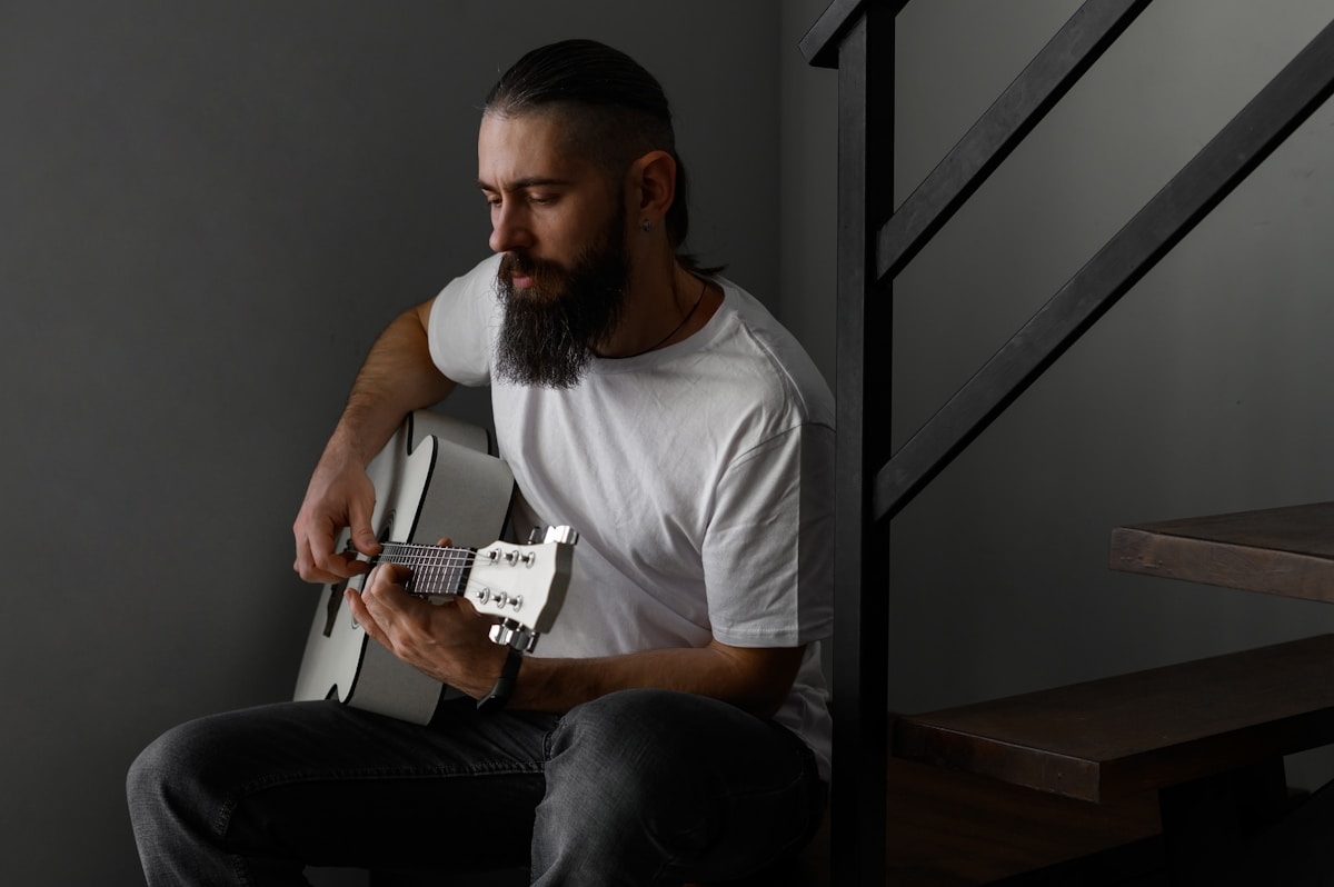 a man with a beard playing a guitar