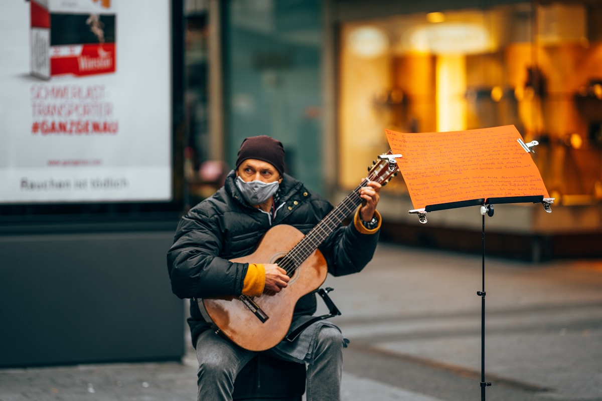 man in black leather jacket playing guitar