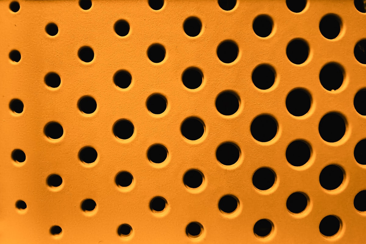 a close up of a metal grate with holes