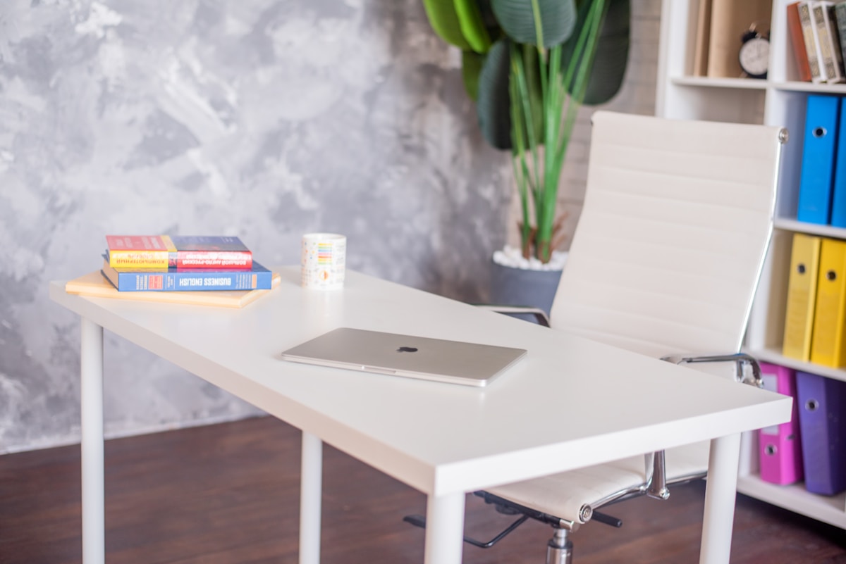 a laptop computer sitting on top of a white desk