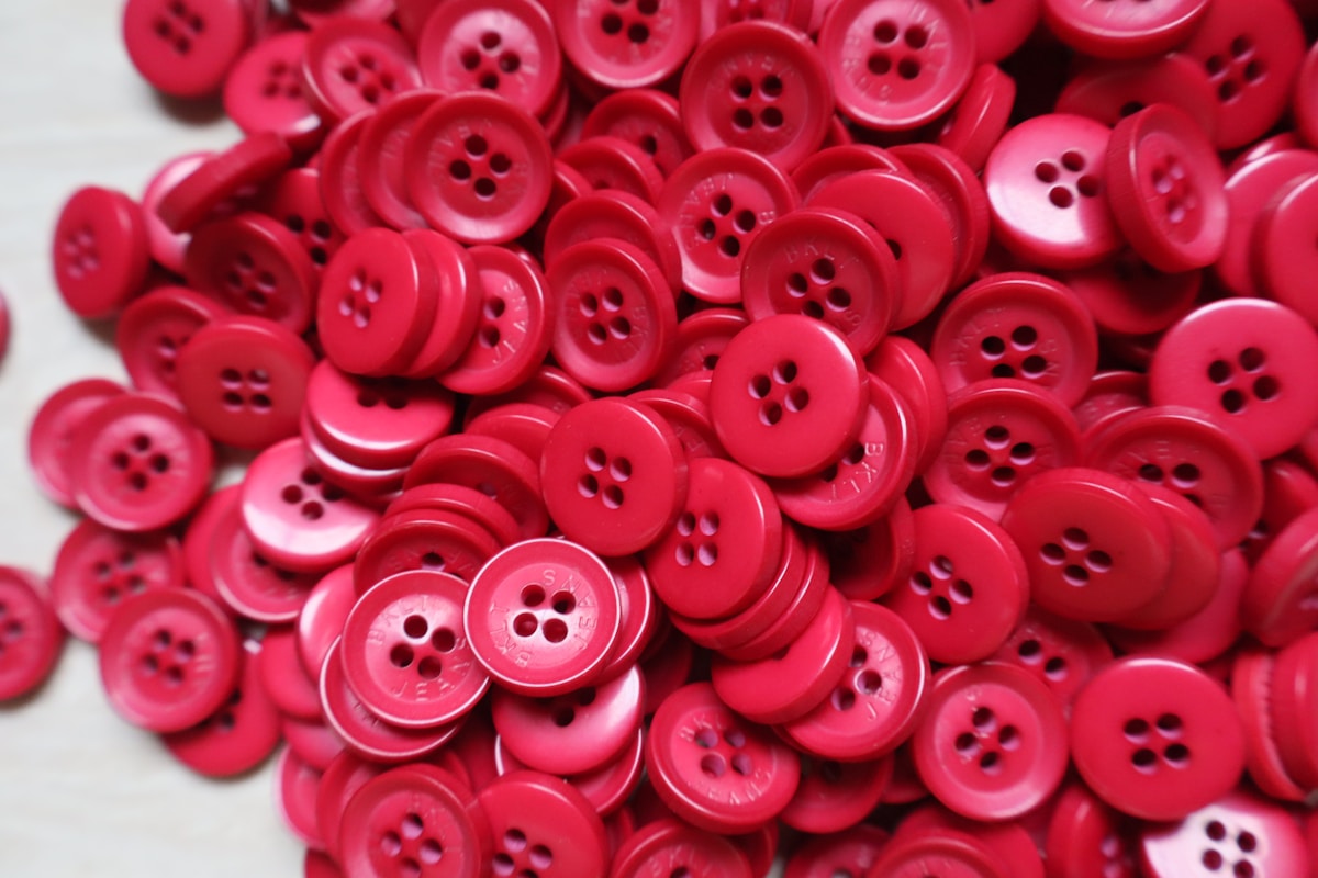 A pile of red buttons sitting on top of a table