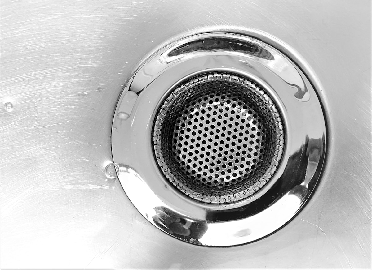Filtre de douche chromé avec motif de nid d'abeille.