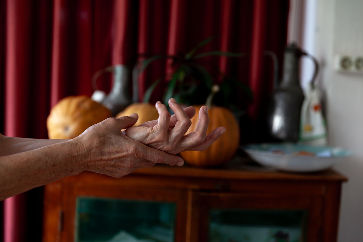 An older woman holding a pumpkin in her hand