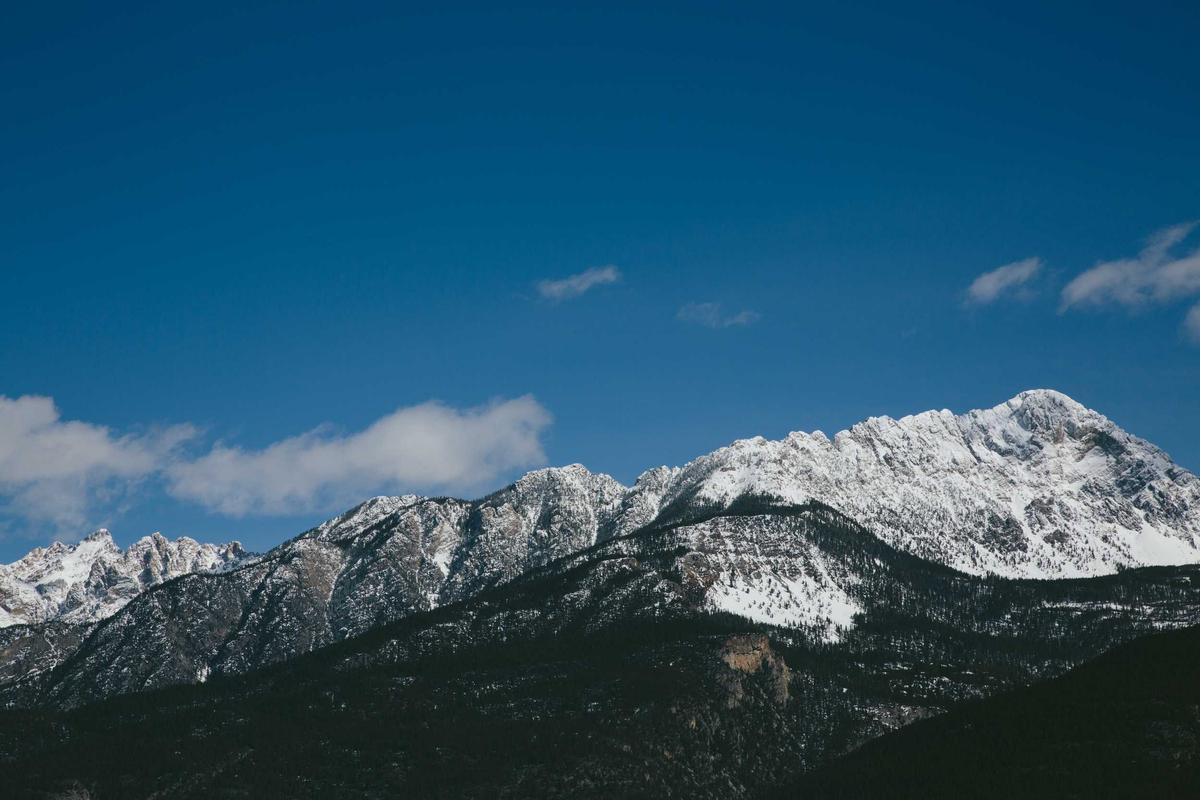 Majestic snow-capped mountains against a vibrant blue sky.