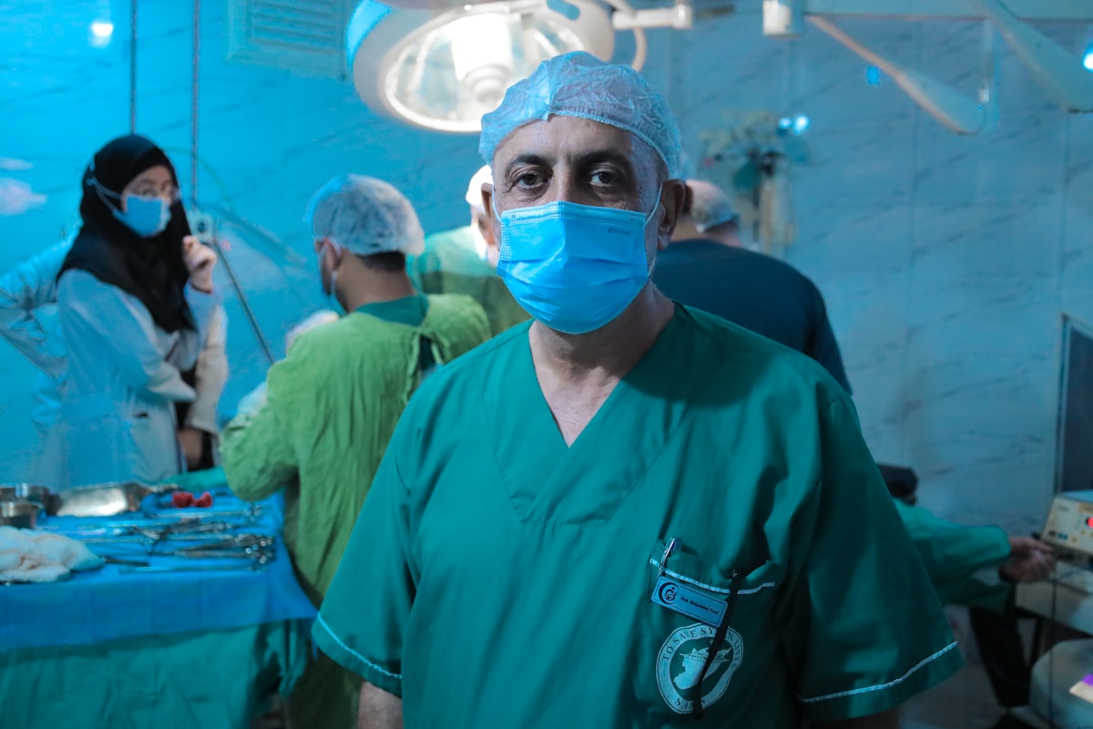 A man wearing a surgical mask standing in a room