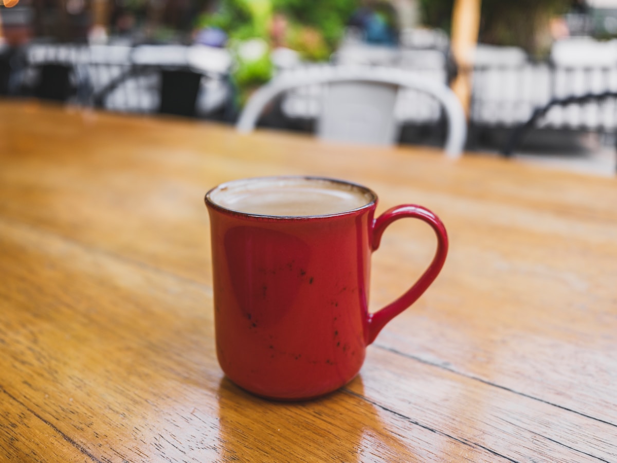 Red mug with coffee on a wooden table