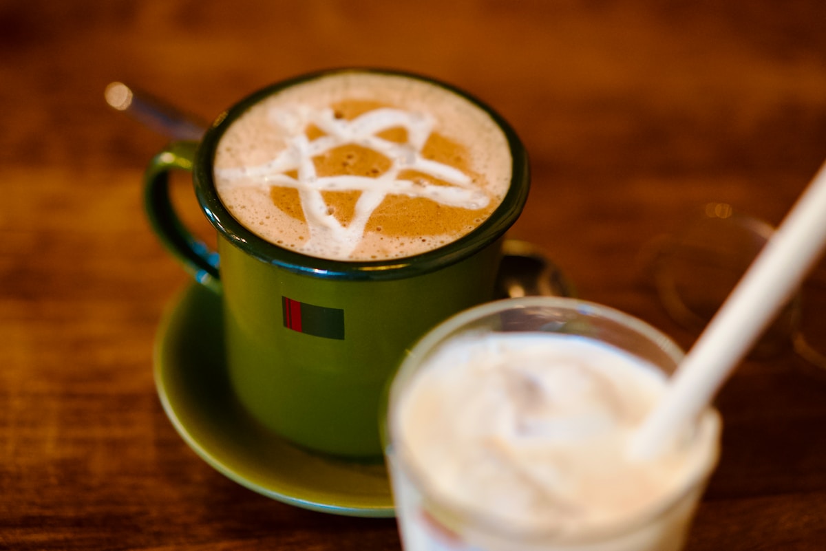 Deux boissons avec des motifs de latte art sur une table.