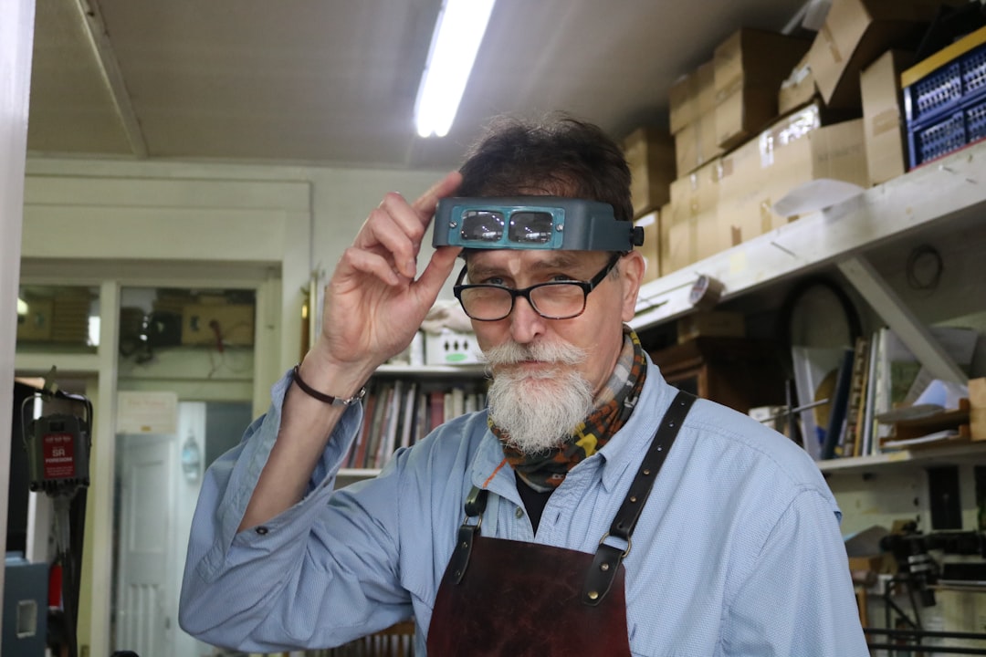 "Mains d'un bijoutier expert sertissant un diamant dans un anneau or sur mesure, outils de précision et gemmes sur un établi,