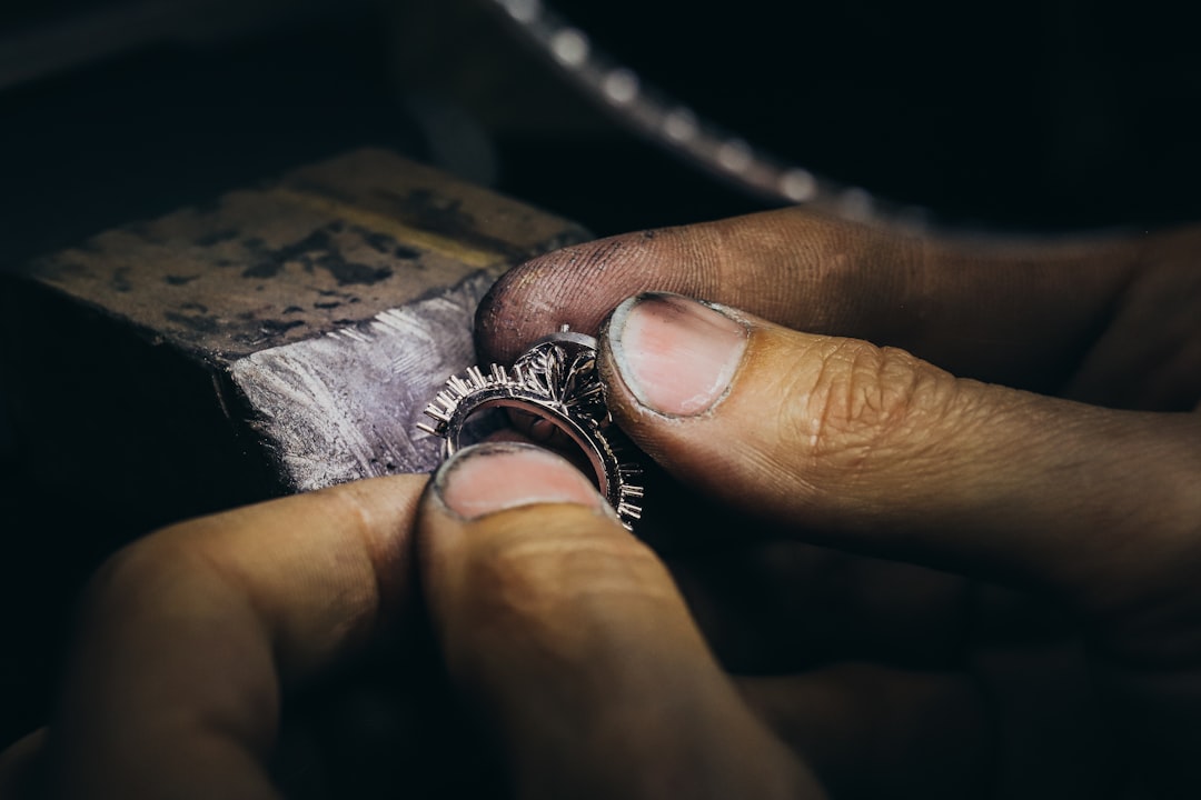 "Un bijoutier restaure un bracelet en argent avec précision, sur un établi en velours, dans le cadre d'une restauration de bi