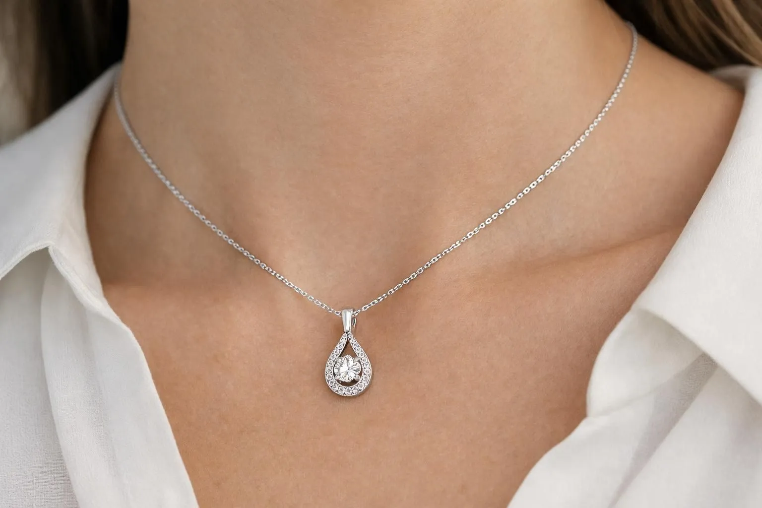 Close-up of white gold pendant necklace with diamond resting on elegant woman's neck, showcasing the rhodium plating's mirror finish and neutral tone against skin in soft natural lighting, professional jewelry photography style