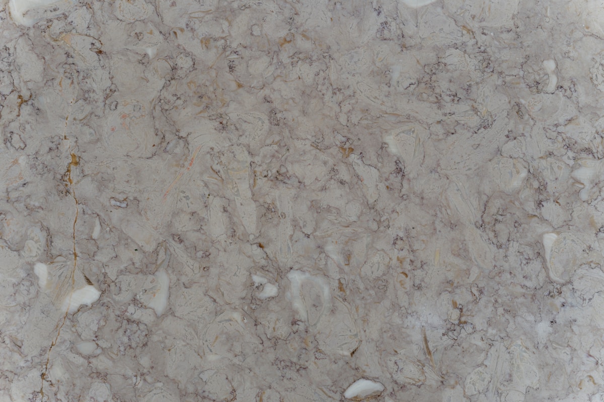 Texture de marbre gris clair avec des veines et des taches.