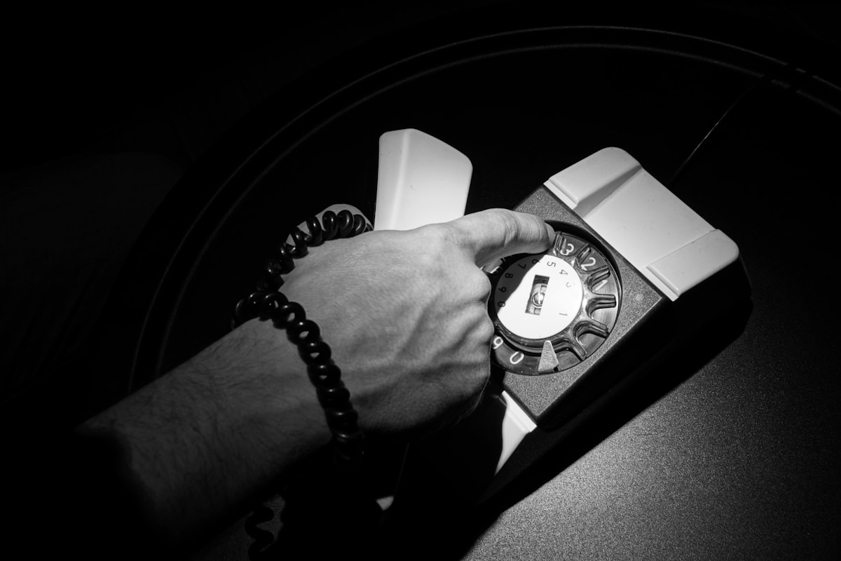 Montre-bracelet analogique blanc et noir sur un poignet avec bracelet en perles.