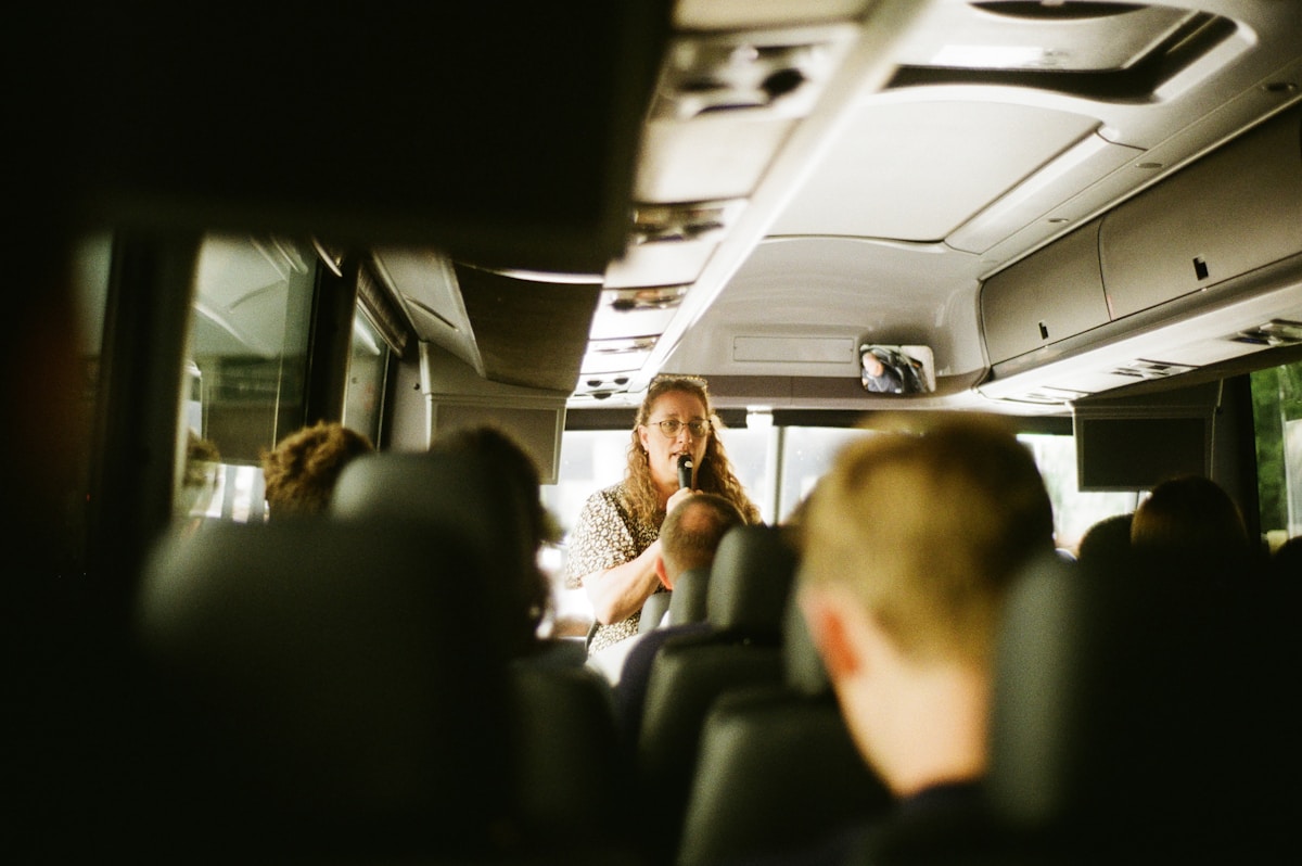 Femme avec des lunettes parlant dans un bus bondé.