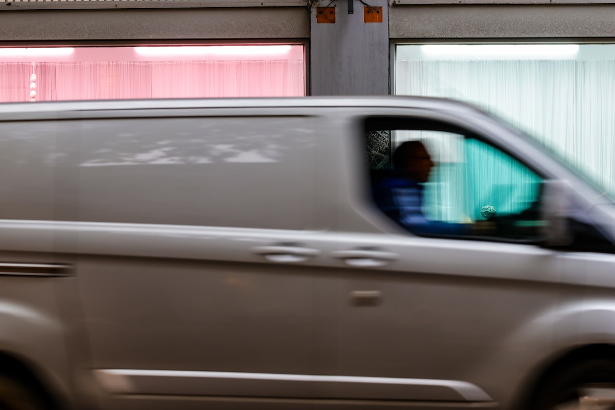 Véhicule en mouvement rapide, reflet flou dans le rétroviseur.