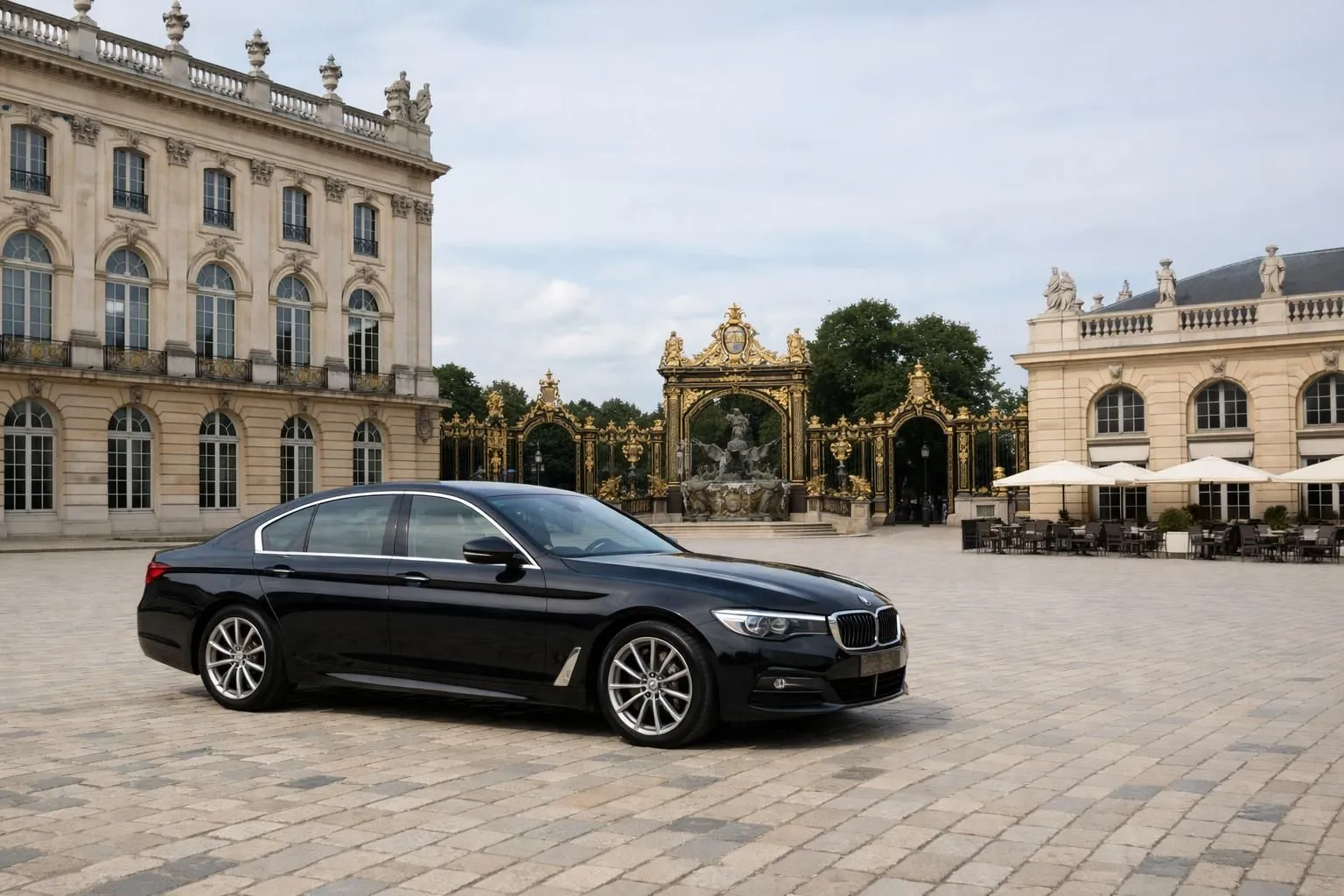 Elegant private chauffeur-driven luxury sedan parked near Place Stanislas golden gates in Nancy, with 18th-century architecture and ornate ironwork visible in background, European sophisticated atmosphere, professional travel service context