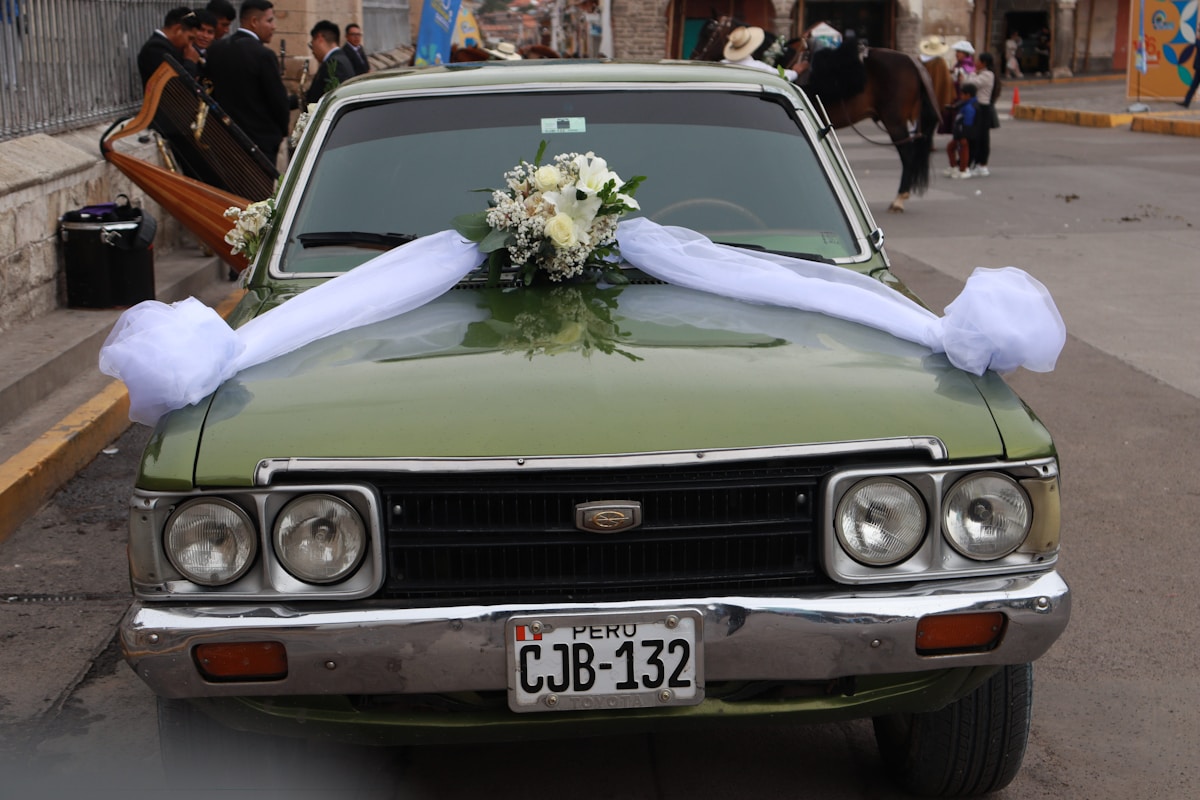 A green car decorated for a wedding