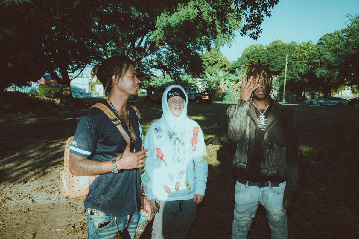 קבוצה של שלושה גברים עומדים זה לצד זה