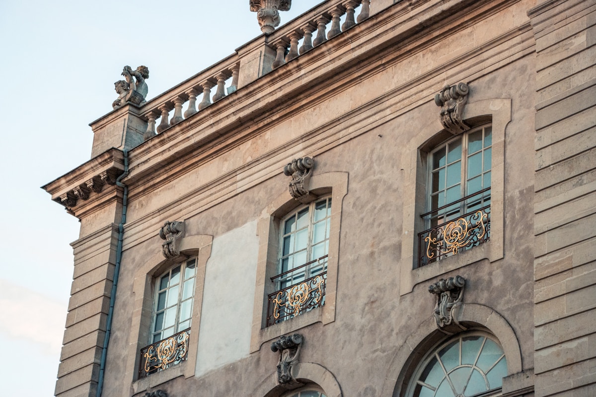 Façade ornementée d'un bâtiment historique avec fenêtres et balcons ouvragés.