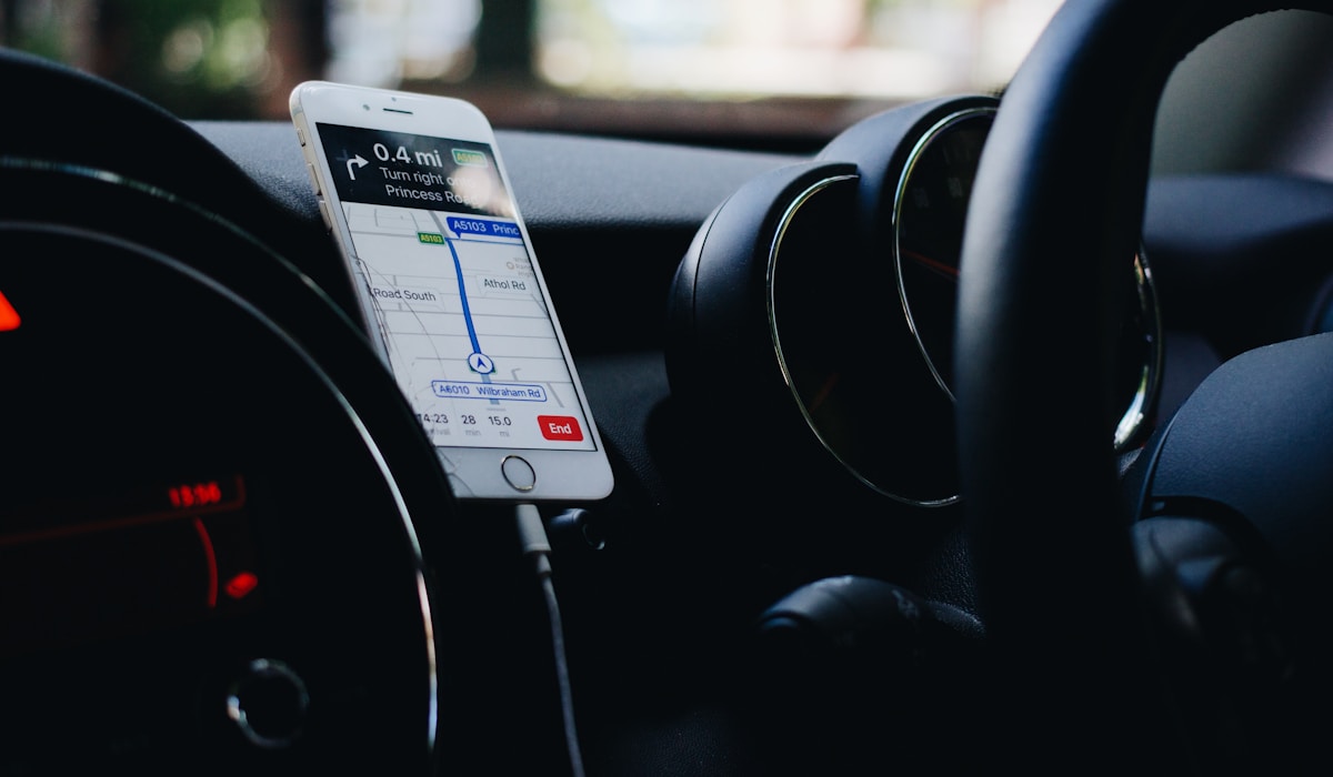 Smartphone monté sur le tableau de bord d'une voiture affichant un itinéraire GPS.