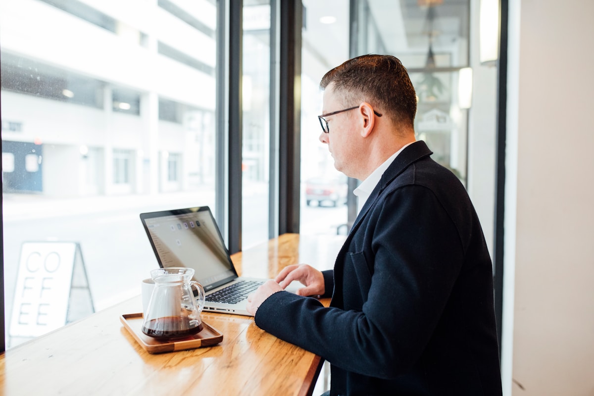 Homme d'affaires travaillant sur un ordinateur portable dans un café.