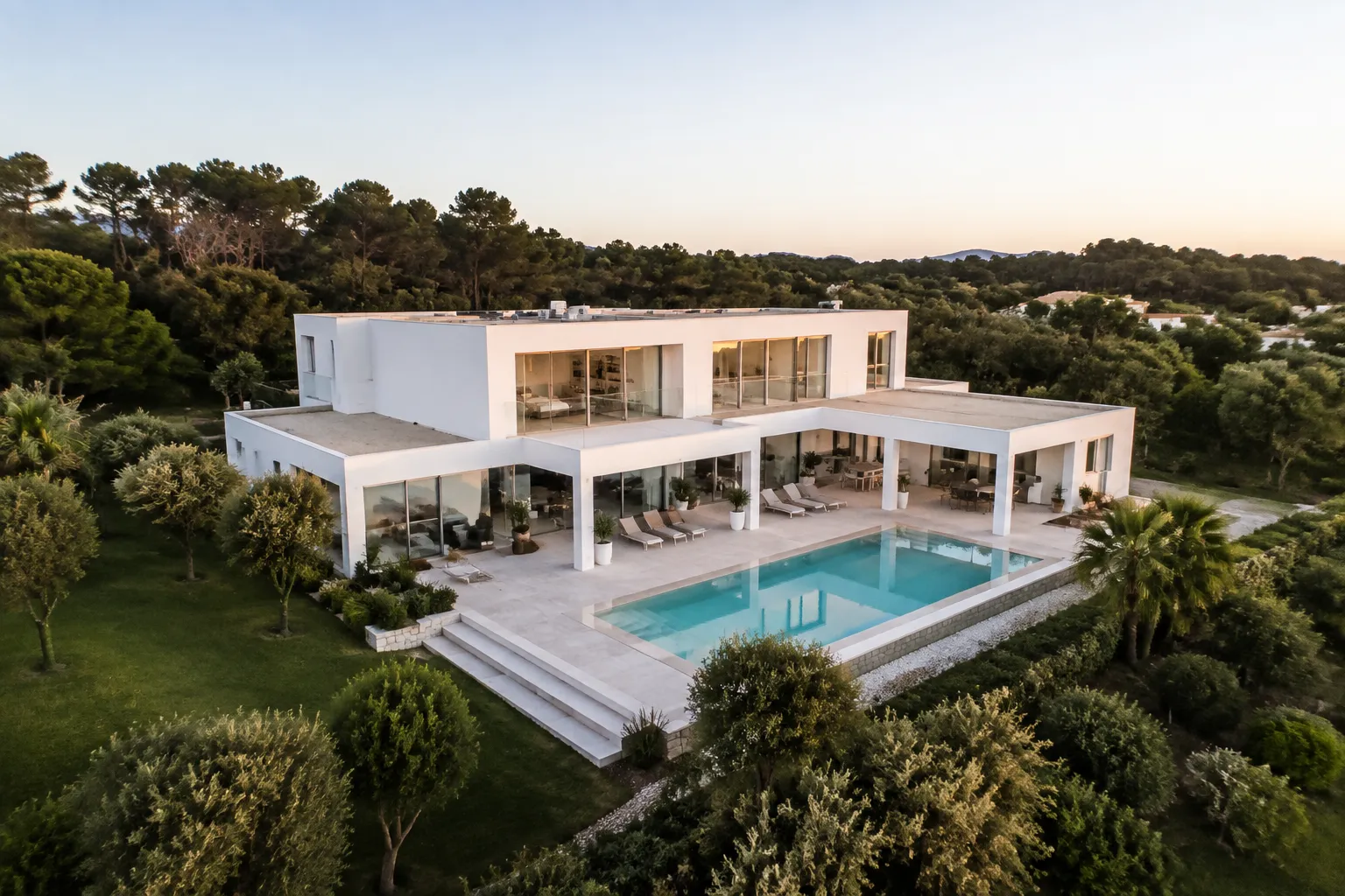 Villa moderne avec piscine dans un paysage verdoyant.