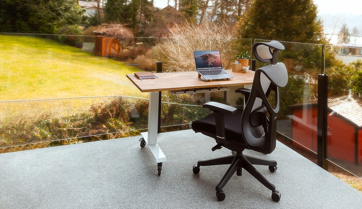 Bureau de travail moderne avec ordinateur portable et chaise ergonomique.