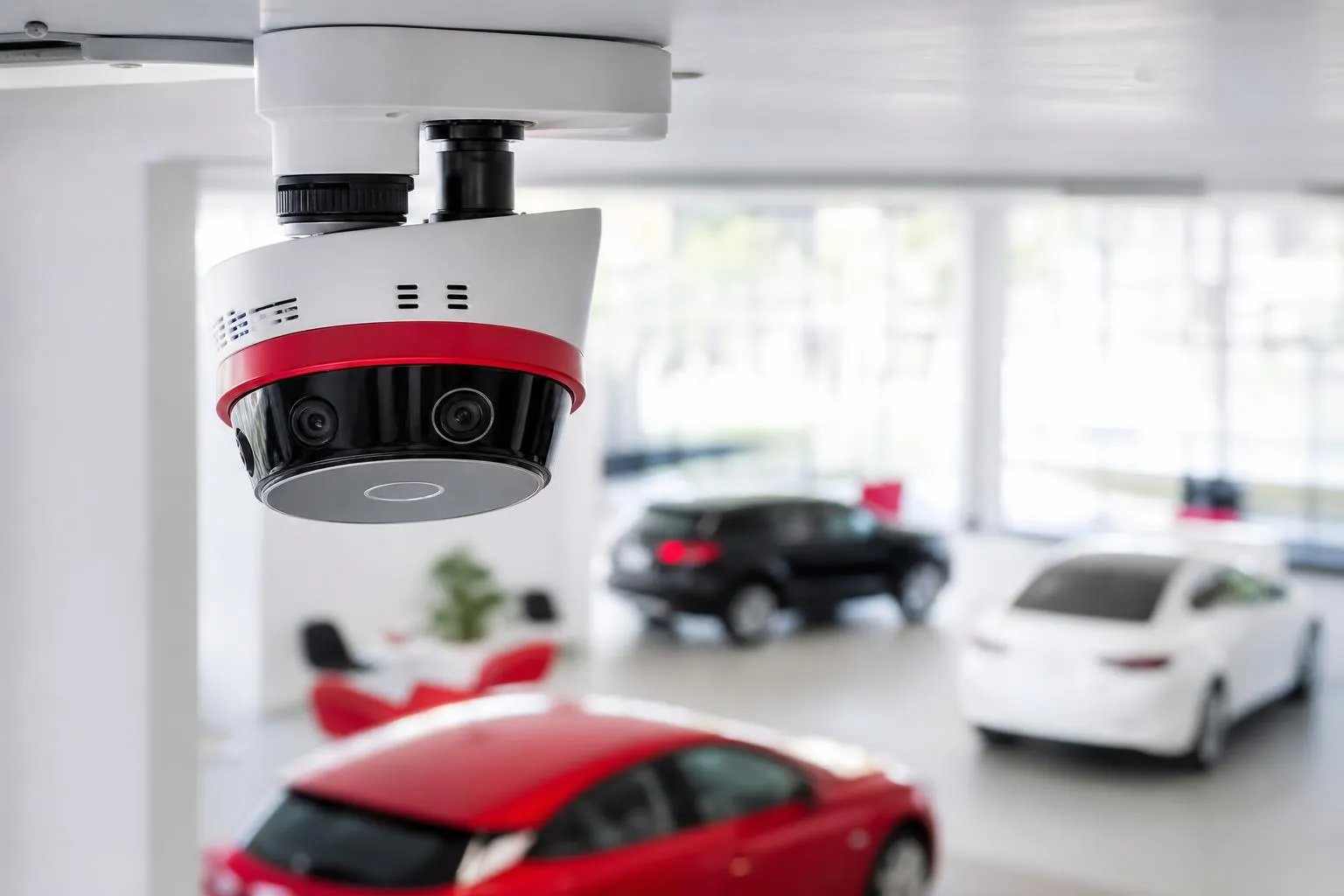 Caméra de sécurité suspendue dans un showroom automobile.