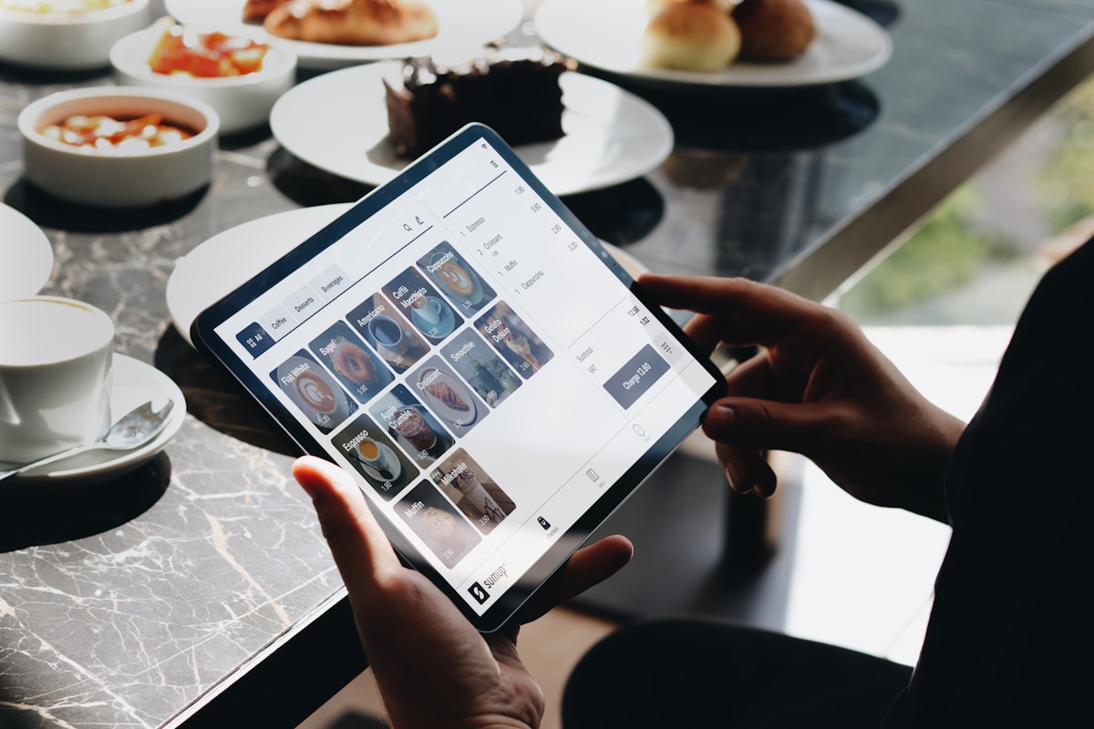 Personne utilisant une tablette pour examiner des images de plats et de desserts.