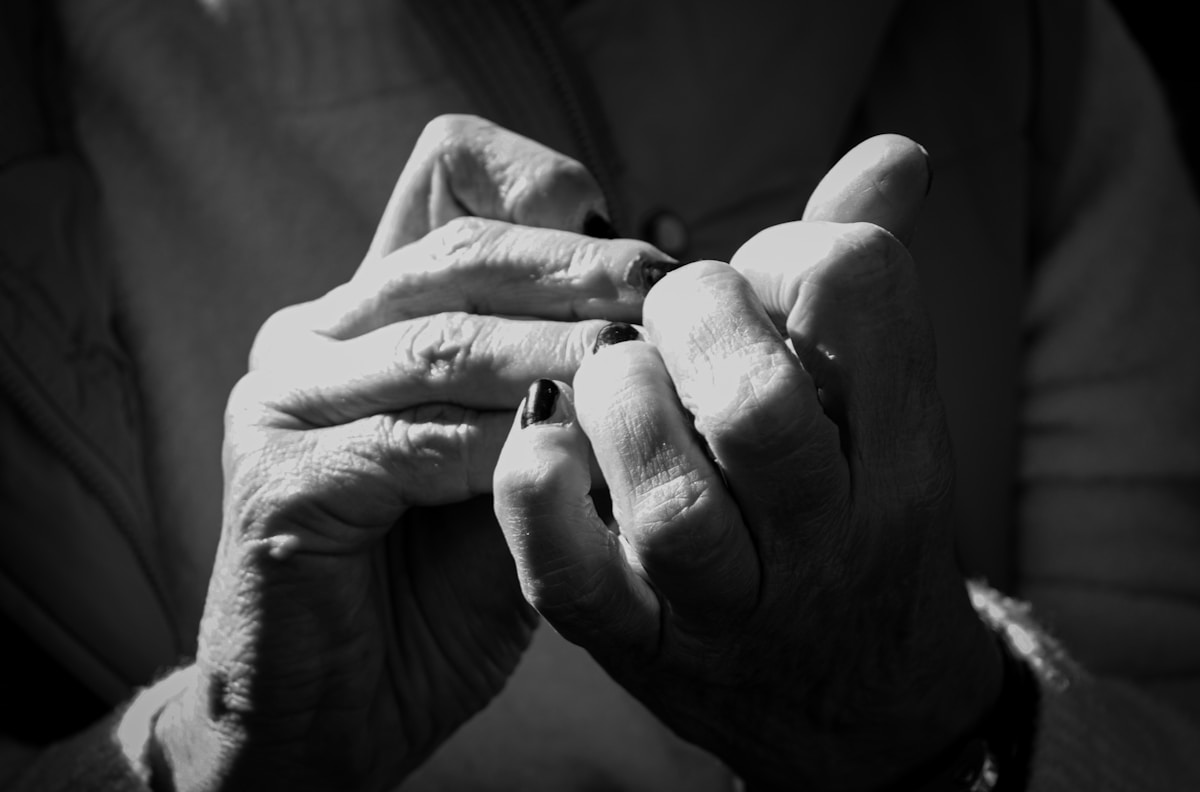 Mains ridées d'une personne âgée, gros plan en noir et blanc.