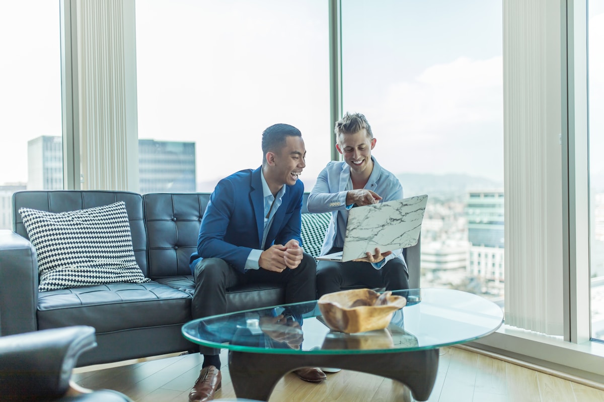Deux hommes d'affaires discutant et travaillant ensemble dans un bureau moderne.