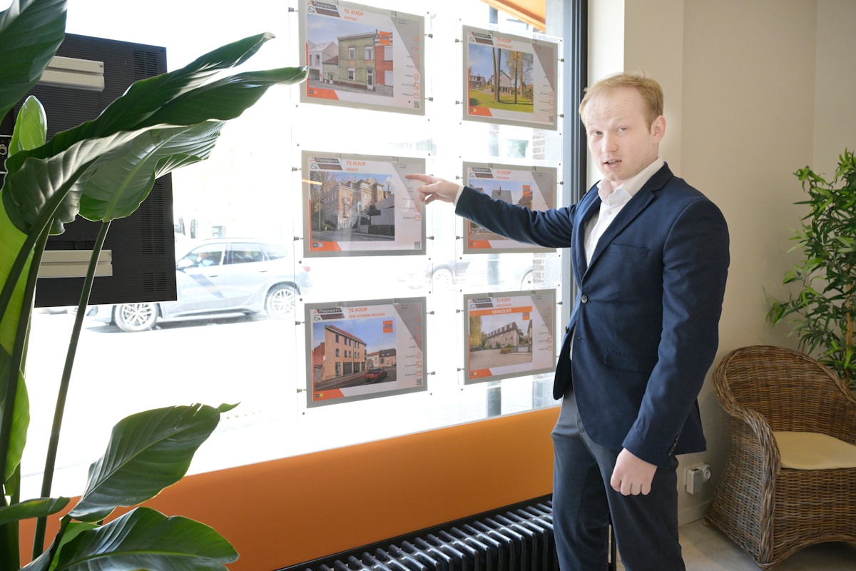 Un agent immobilier présentant des propriétés dans une vitrine.