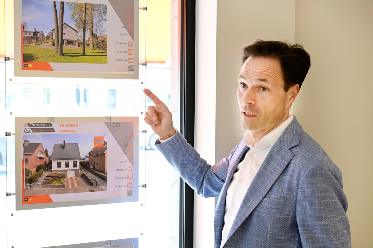 Homme d'affaires examinant des annonces immobilières sur un panneau d'affichage.